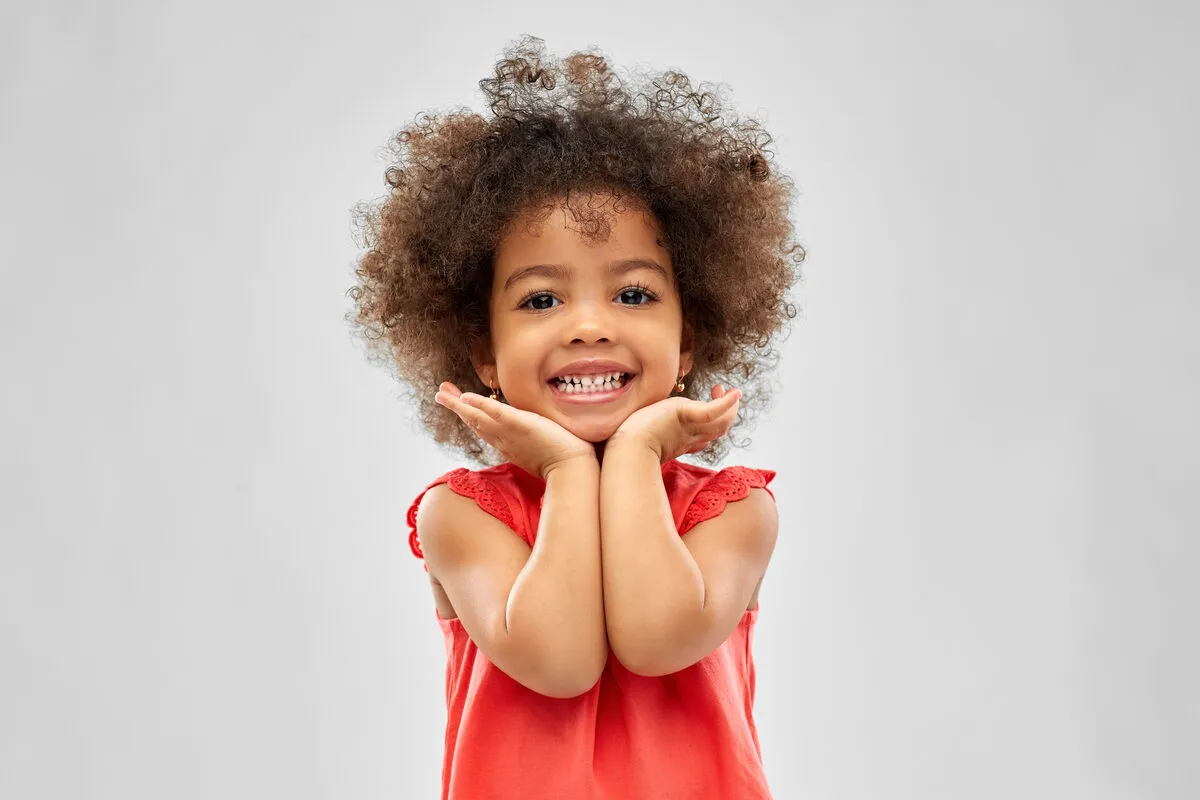 Girl with curly hair showing a bright smile